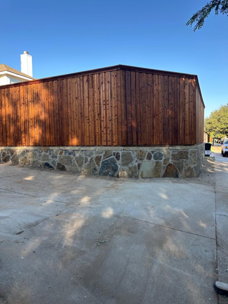 Cedar board-on-board fence built on a natural stone base wall