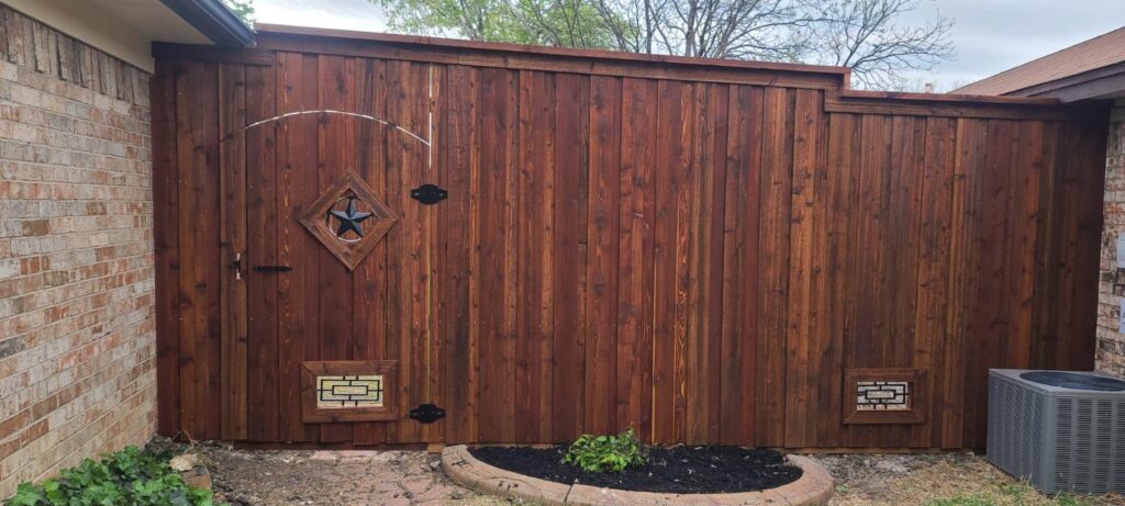 Arched cedar privacy gate with Texas star and diamond cutout in a stained cedar fence
