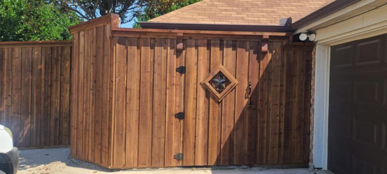 Cedar privacy fence and corner gate with Texas star cutout beside a garage