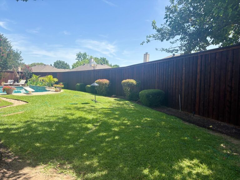 Dark-stained cedar privacy fence enclosing a backyard pool and landscaping