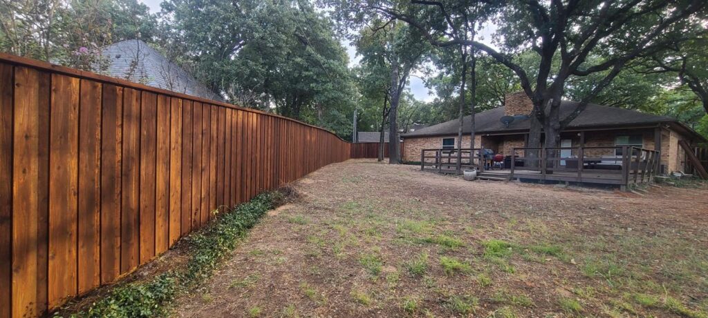 Stained cedar privacy fence enclosing a full backyard in North Texas