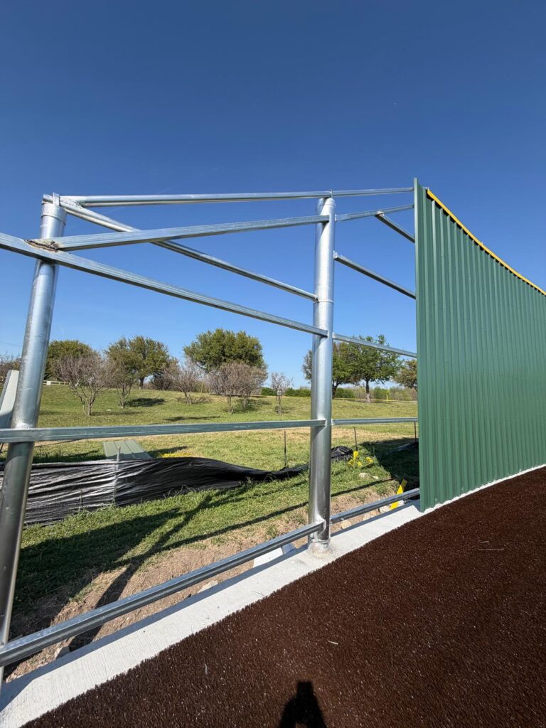 Steel pipe and metal frame ranch fence under construction on Texas acreage
