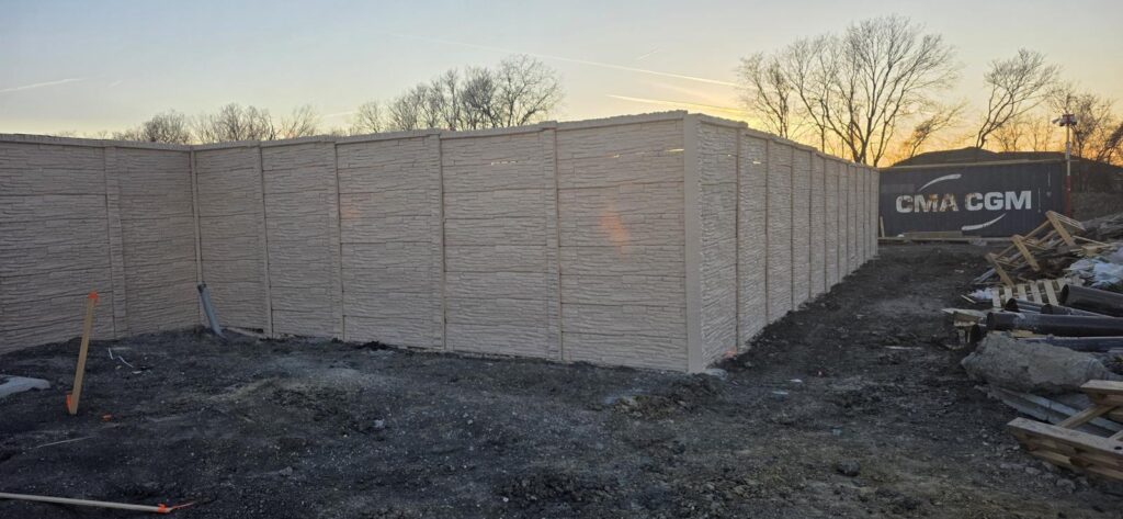 Precast concrete privacy wall along a commercial property at dusk