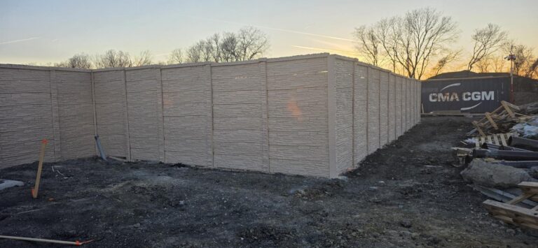 Precast concrete privacy wall along a commercial property at dusk