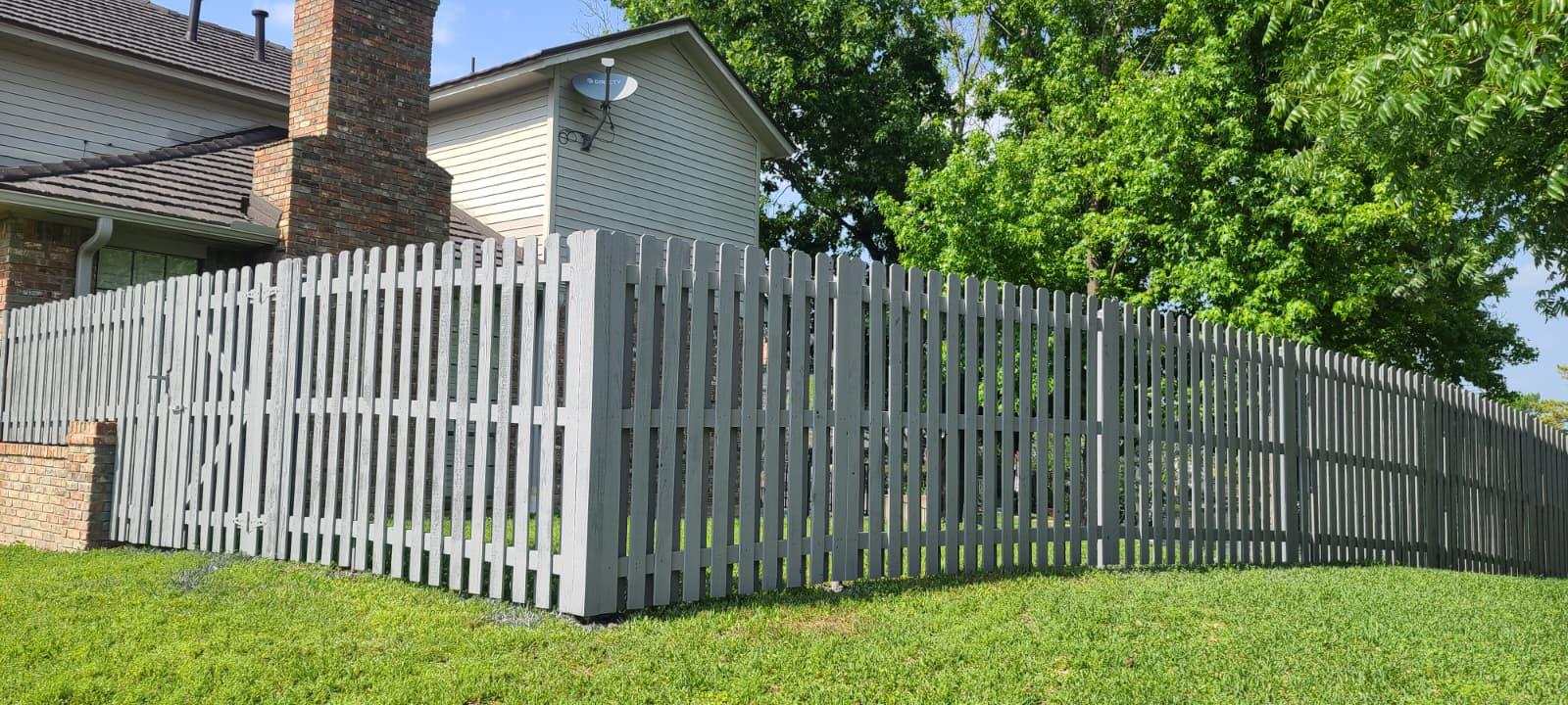Gray painted wood picket fence framing a front yard in the DFW metroplex