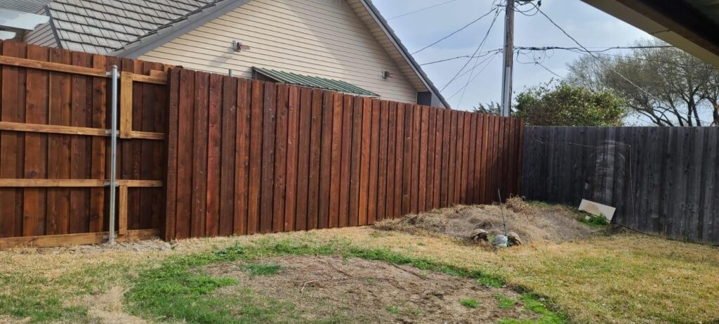 Stained board-on-board cedar fence running along a side yard