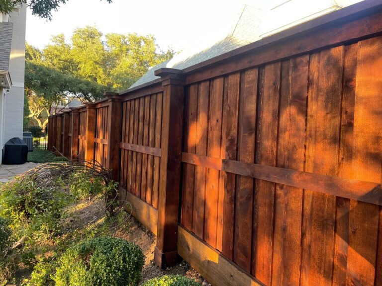 Stained cedar cap-and-trim fence glowing in late afternoon light