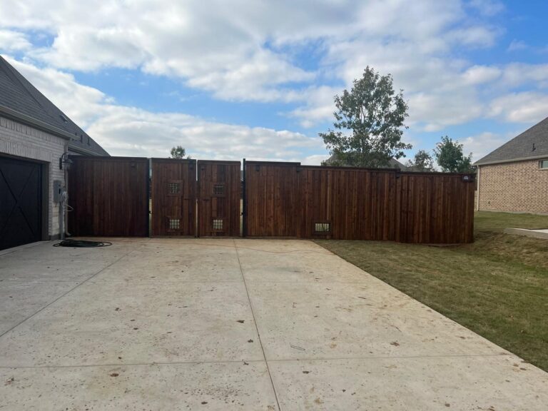 Stained cedar driveway gates closing off a side drive between two homes