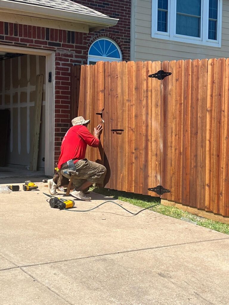 Grace Construction installer fitting hardware on a new cedar gate