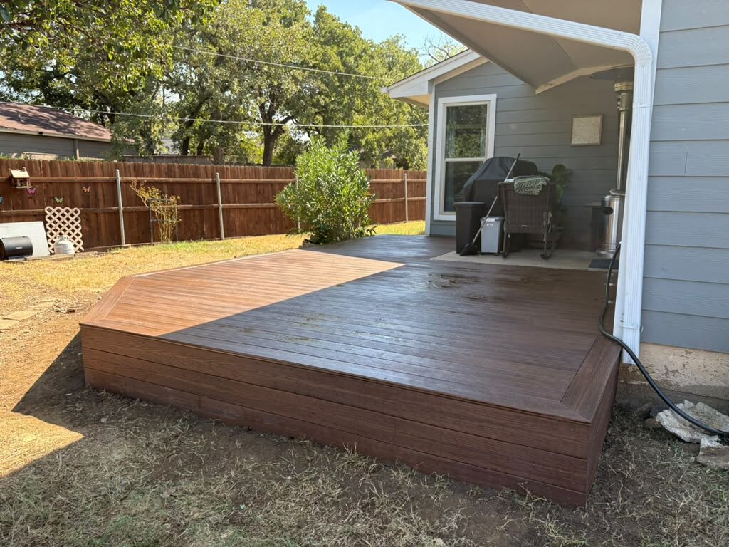 Composite deck with picture-frame border and fascia boards off a covered patio