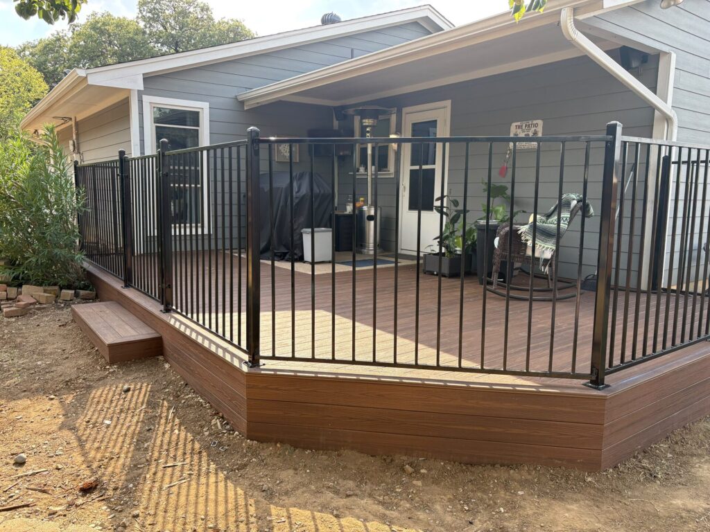Composite deck enclosed with black metal picket railing along an angled edge