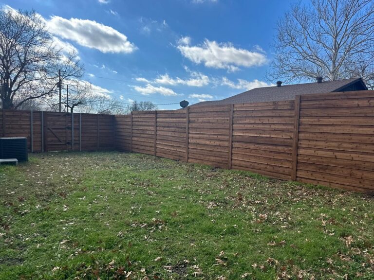 Modern horizontal cedar fence enclosing a backyard lawn